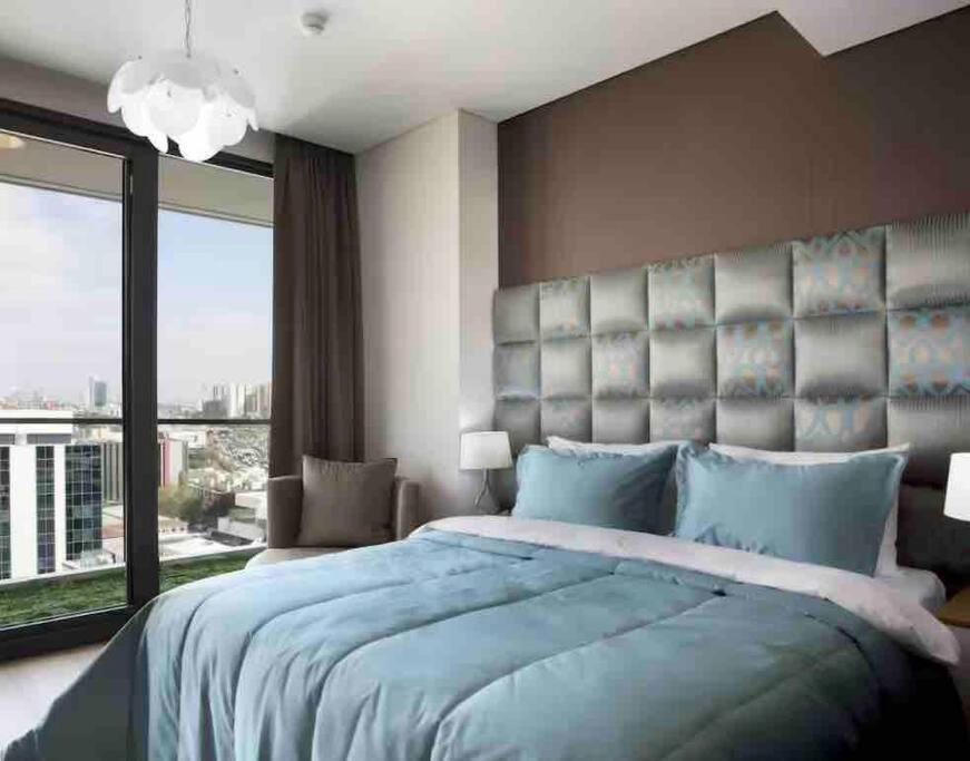 - une chambre avec un grand lit et une grande fenêtre dans l'établissement Cosy 1+1, à Istanbul