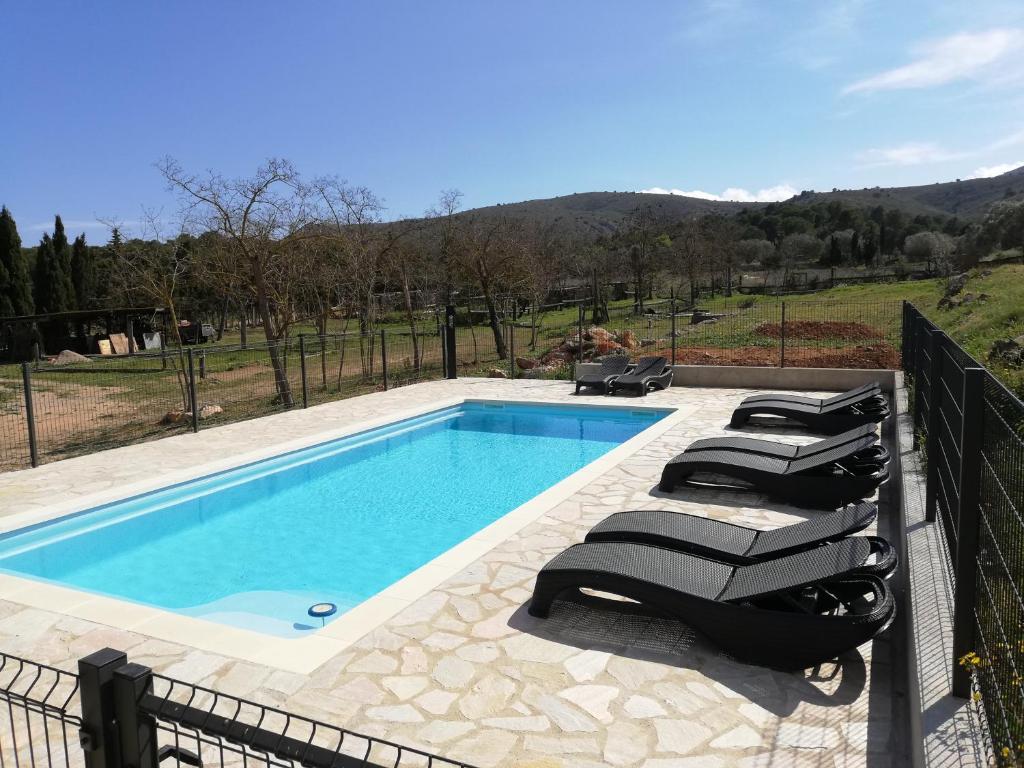 a swimming pool with lounge chairs next to a fence at Mas Del Llop Blanc - Dog friendly Hostal Rural - B&B in Sobrestany