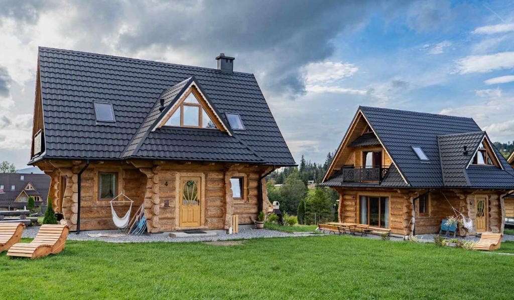 a log house with a black roof on a yard at DOMEK Z BALA ELITA in Kościelisko