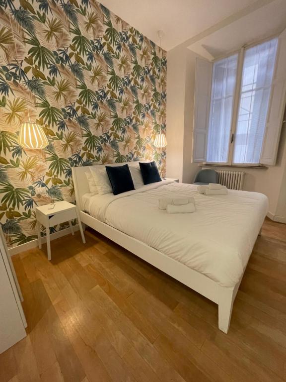 1 dormitorio con 1 cama blanca grande y papel pintado con motivos florales en Piazza del Popolo Luxury Apartament, en Roma