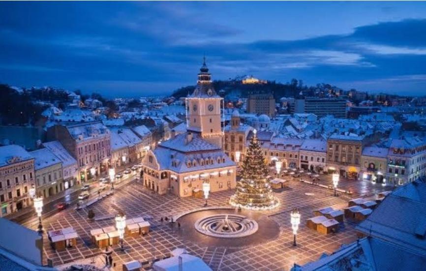 a city at night with a christmas tree in the middle at Luxury Apartment in Braşov