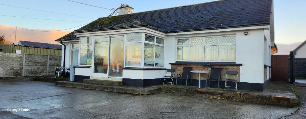 a white house with a table and chairs outside at Fox Lodge in Drogheda