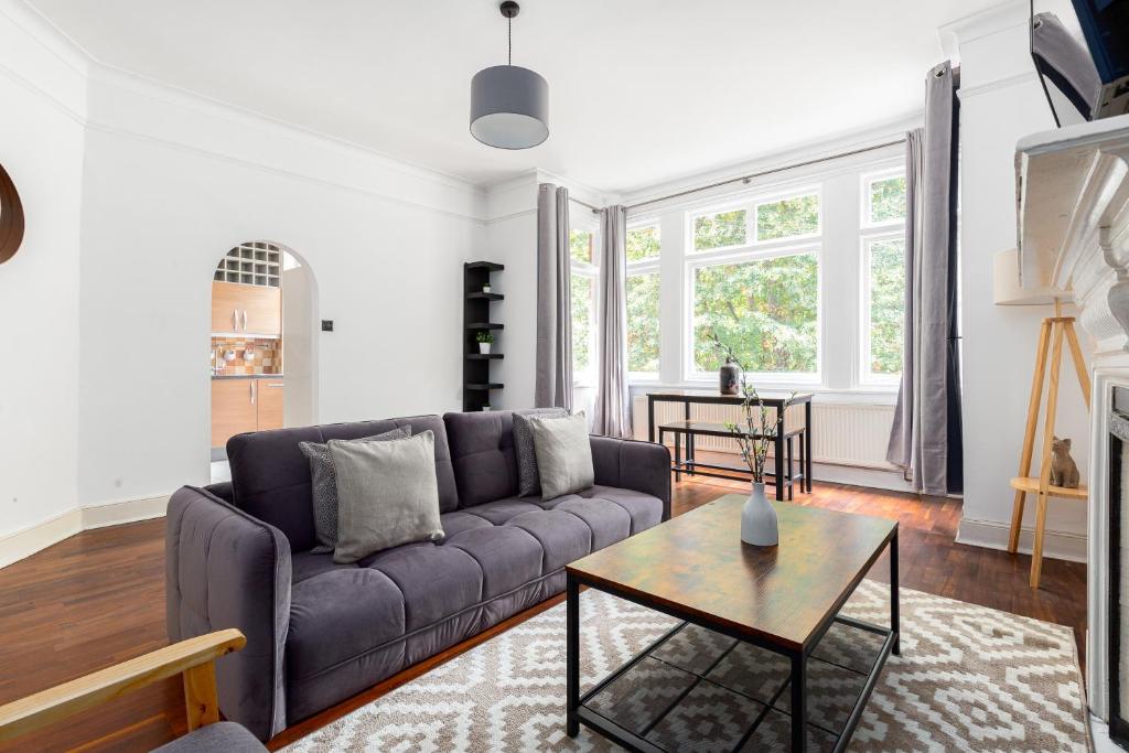 sala de estar con sofá y mesa en The Chiswick Apartments, en Londres