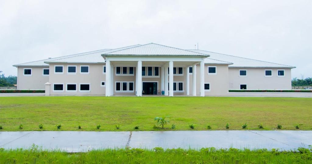 a large white building with a large grass field at TIME Royal Ambassador Hotel in Harbel