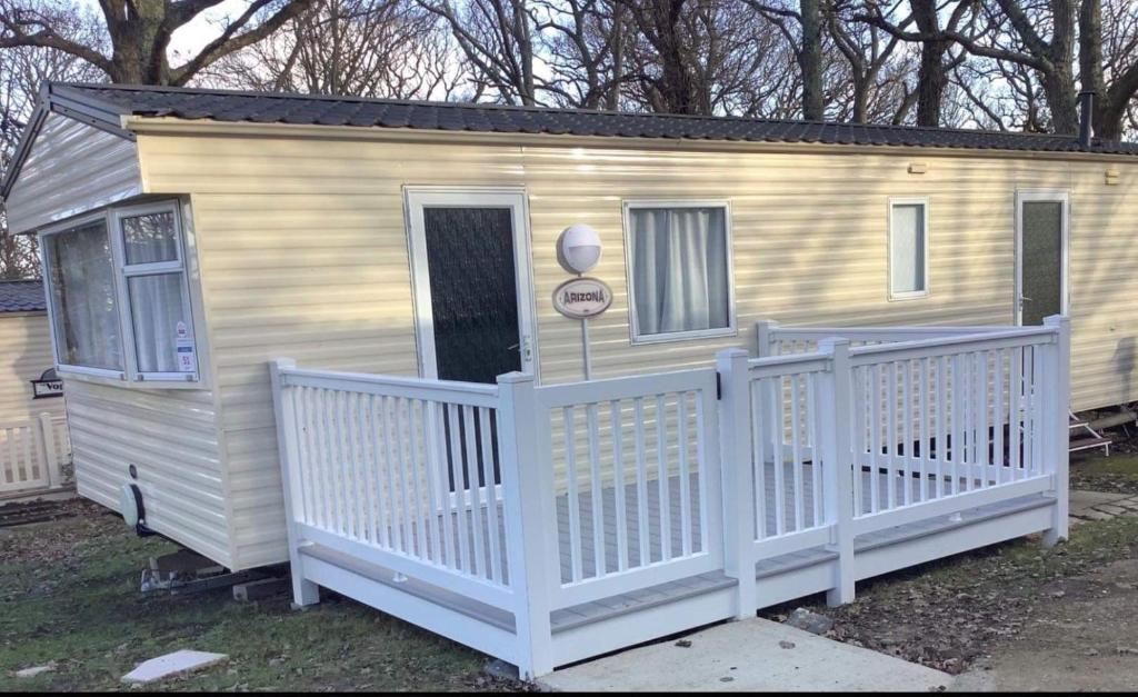 a small white house with a white fence at 51 Oaklands thorness bay Parkdean holiday resort in Cowes