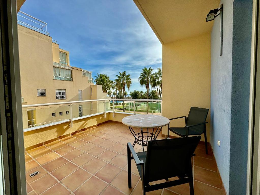 a balcony with a table and chairs on a balcony at Apartamento con vistas al mar en urbanización de lujo Almerimar in Almerimar