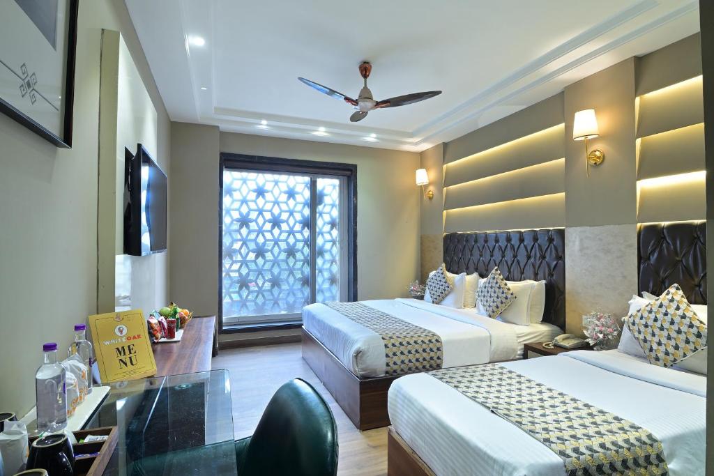 een hotelkamer met 2 bedden en een bureau bij Hotel Oak Plaza, New Delhi in New Delhi