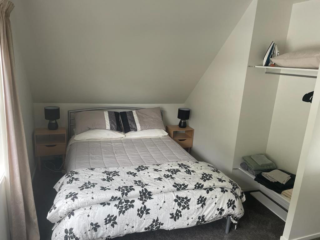 ein kleines Schlafzimmer mit einem Bett mit einer schwarzen und weißen Bettdecke in der Unterkunft Ohope Dreamer 1 in Ohope Beach