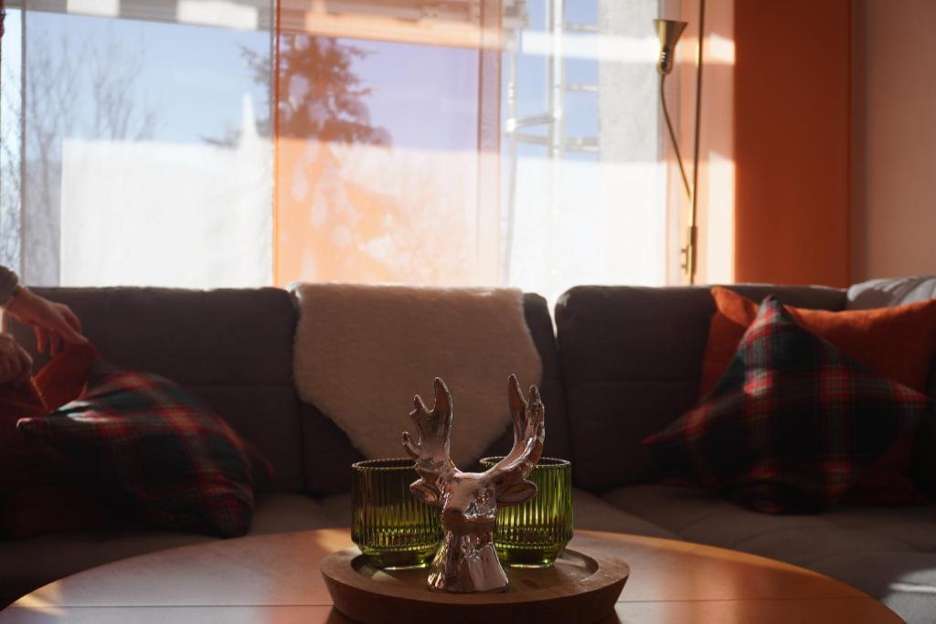 a statue of a deer on a table in front of a couch at FeWo AllgäuZeit mit Hallenbad & Sauna & kostenlosem WLAN in Missen-Wilhams