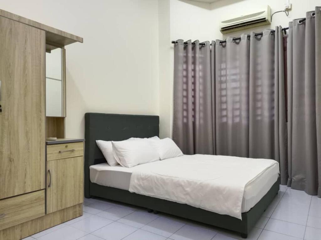 Kampung Bota Kiri的住宿－KhaAfi Homestay Seri Iskandar，一间卧室配有床、梳妆台和窗帘