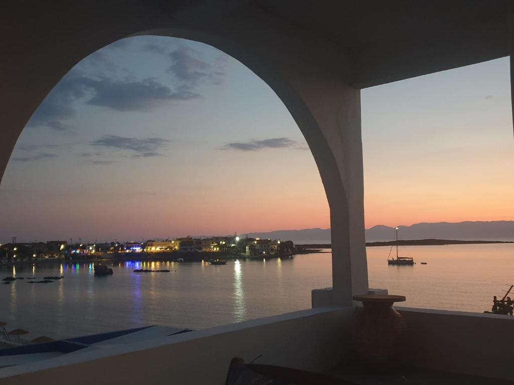 an arched window with a view of the water at Sunset Holiday House in Archangelos