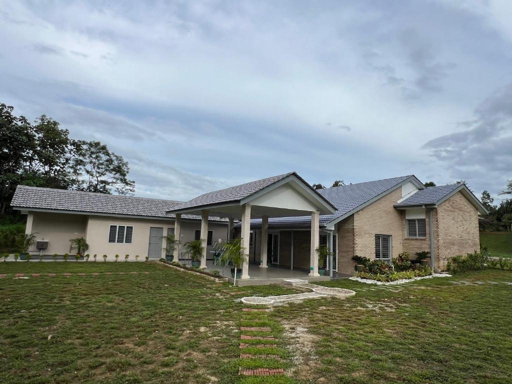 une maison avec une grande cour devant elle dans l'établissement Sunny Lake House, à Behrang Hulu