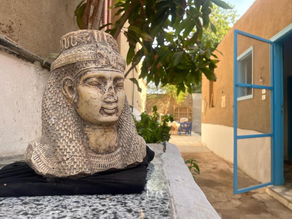 a statue of a head sitting on a wall at Nobian House Studios #1 in Luxor