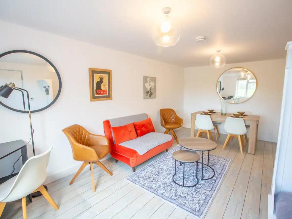 a living room with a red couch and a table at Pass the Keys Stylish apartment in peaceful Oxfordshire suburb in Kidlington