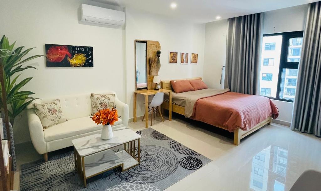 a bedroom with a bed and a couch and a table at Căn hộ studio Vinhomes Grand Park, Thủ Đức city, Hồ Chí Minh city in Long Bình
