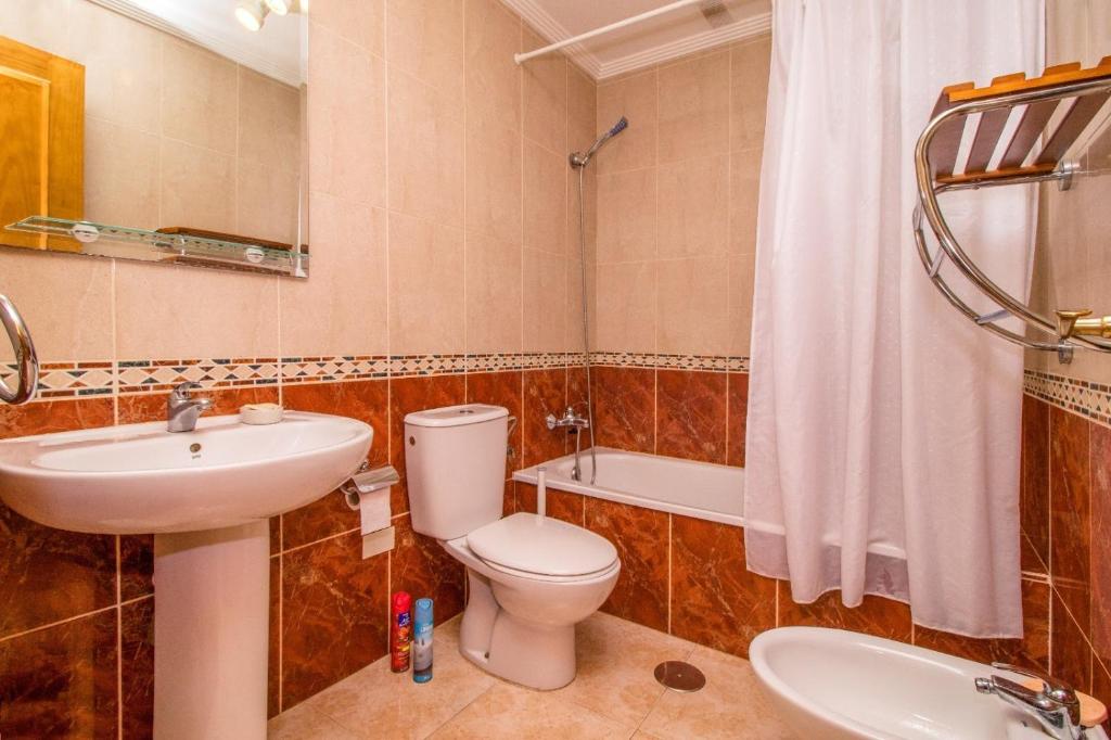 a bathroom with a toilet and a sink and a tub at Parque De Las Naciones Dragon con garaje ! in Torrevieja