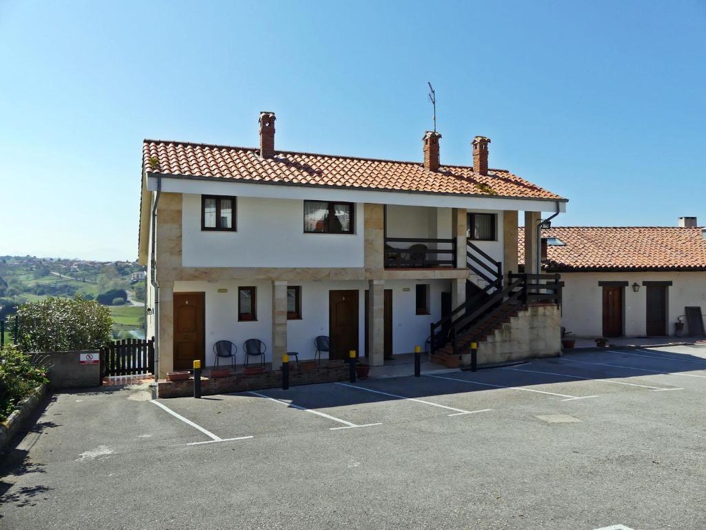 a large white house with a parking lot at El Mirador de Trasvia Comillas in Trasvia