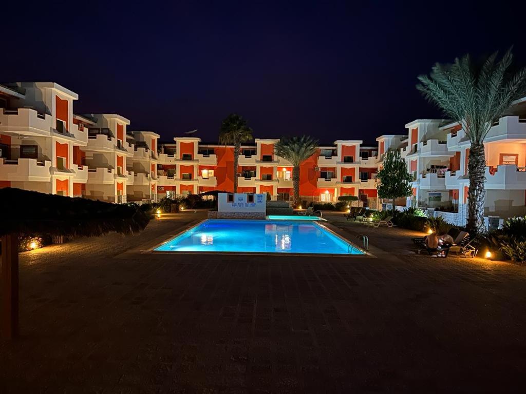 un gran complejo de apartamentos con piscina por la noche en MORADIAS I02/C, en Prainha