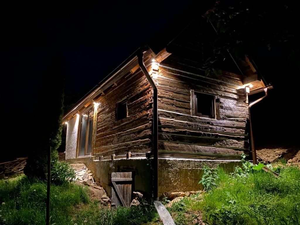 una vecchia baita di tronchi con luci accese di notte di RelaxLak 