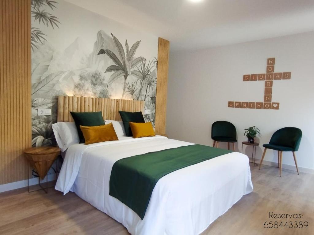 a bedroom with a large bed with yellow and green pillows at Ciudad Rodrigo Centro in Ciudad-Rodrigo