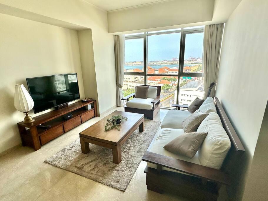 ein Wohnzimmer mit einem Sofa und einem Flachbild-TV in der Unterkunft Colombo Emperor Residencies in Colombo