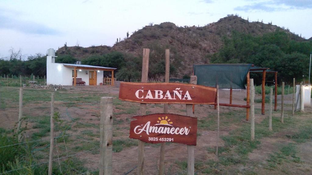 a sign in front of a building with a mountain at Cabaña "Amanecer" in Chilecito