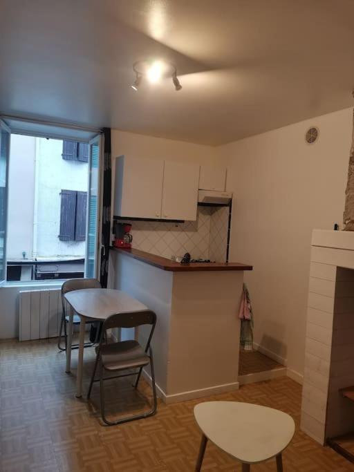 een keuken met een tafel en stoelen in een kamer bij T1 bis centre ville d'Aurillac in Aurillac