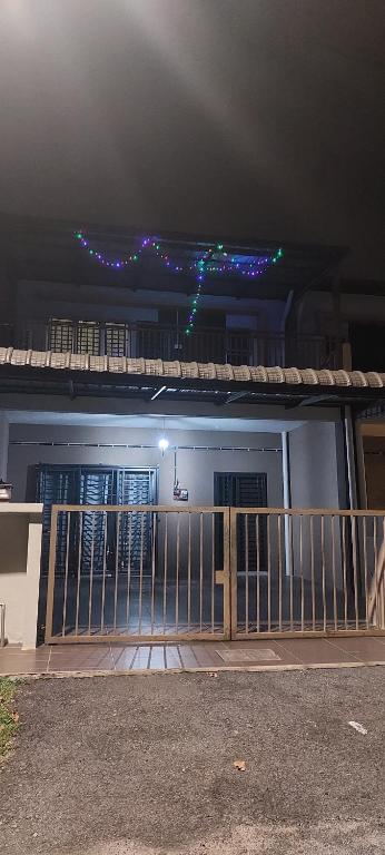 a house with a gate with lights on it at TIQ Homestay KLIA in Sepang