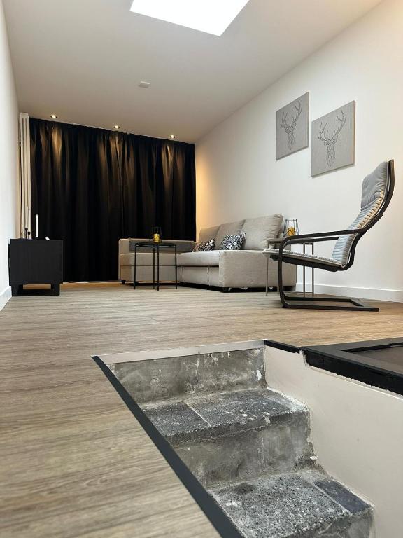 een woonkamer met een bank en een stoel bij luxe pas gerenoveerd monumentaal appartement in Maastricht