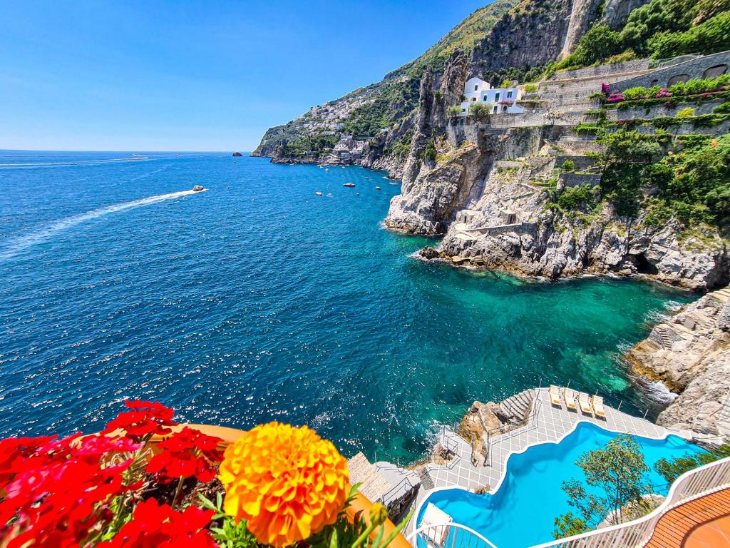 a view of the ocean from a cliff with flowers at Villa Costa degli Dei in Furore