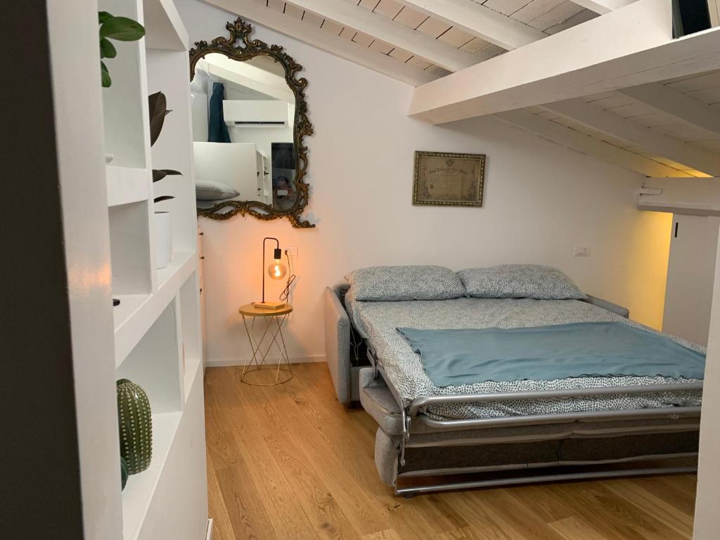 a bedroom with a bed and a mirror on the wall at Via Pia 29-7 in Savona