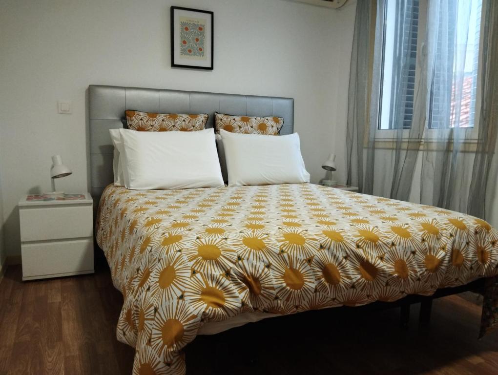 um quarto com uma cama com um edredão amarelo e branco em Apartamento Burgo " A Preferida " no Funchal