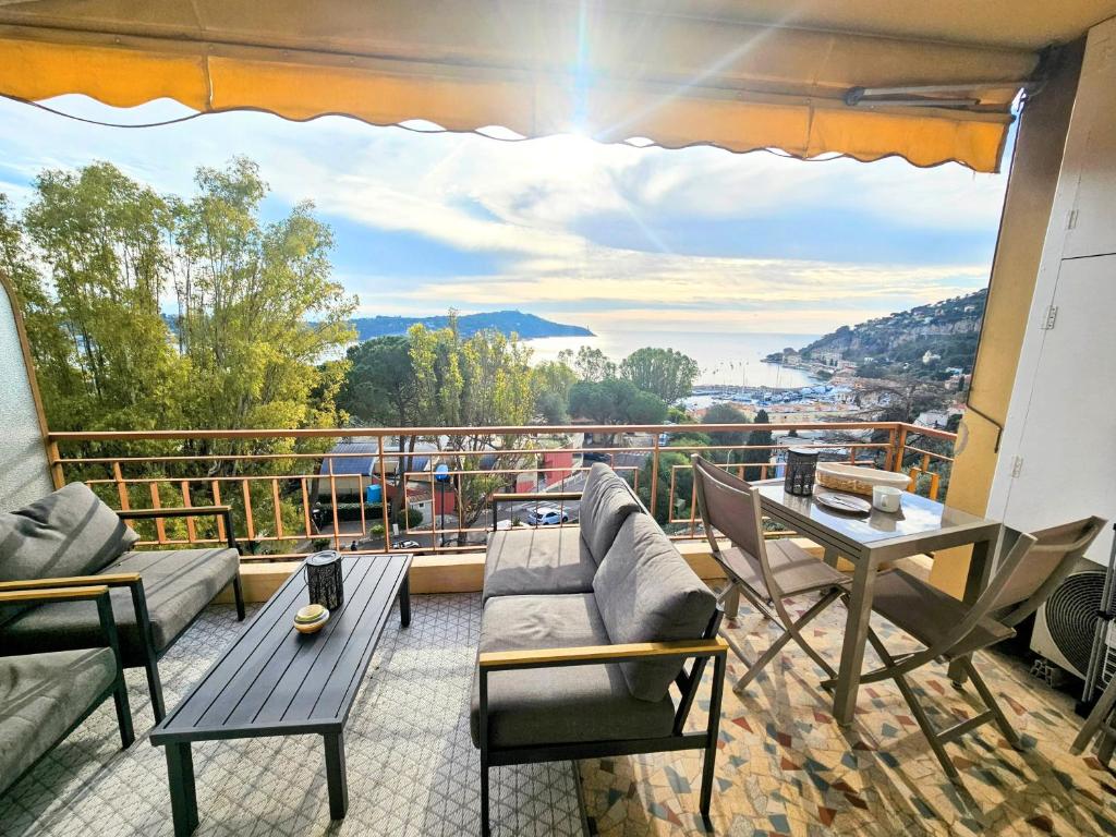 a balcony with a couch and chairs and a table at Villefranche center Bay & Port Sea view front in Villefranche-sur-Mer