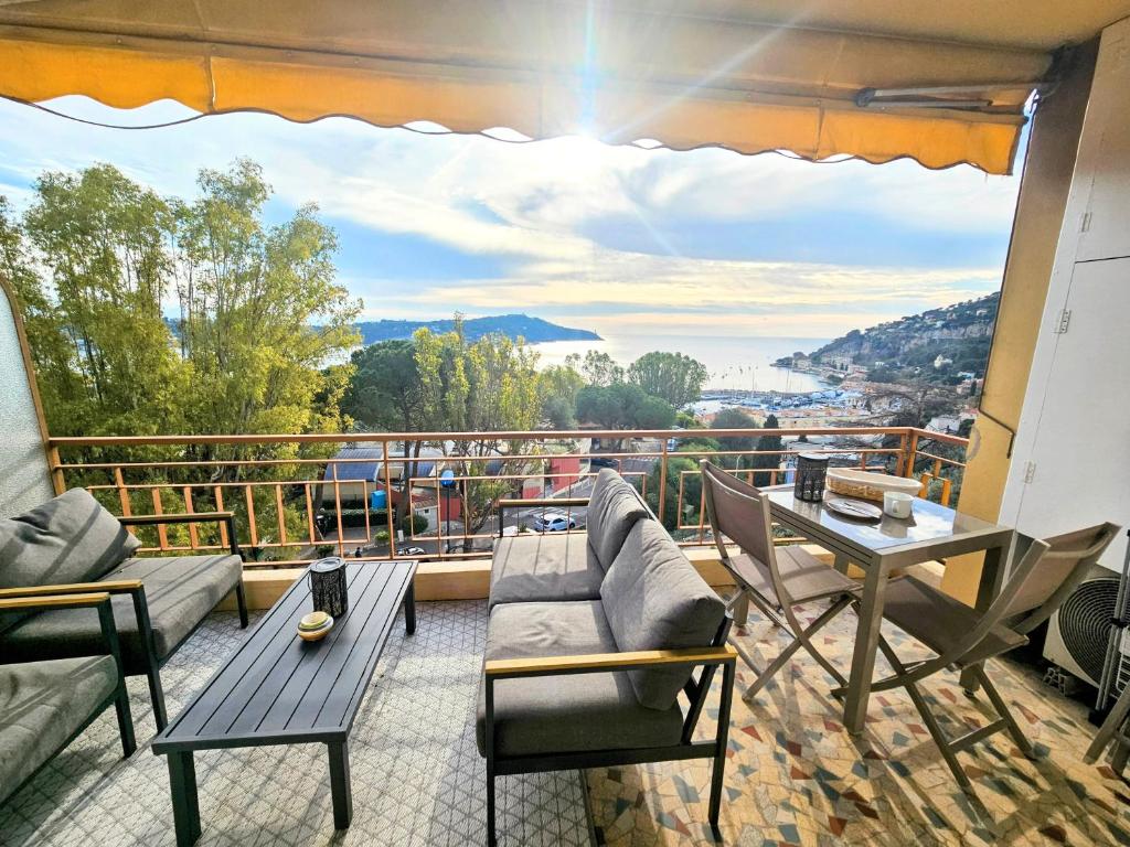 un balcon avec un canapé, des chaises et une table dans l'établissement Villefranche center Bay & Port Sea view front, à Villefranche-sur-Mer