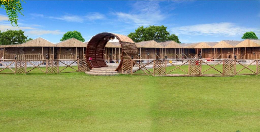 un gruppo di capanne in un campo erboso di Gopika Resort a Vrindāvan