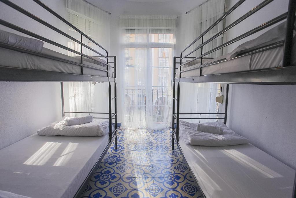 two bunk beds in a room with a window at BBTK Bed and Bike in Málaga