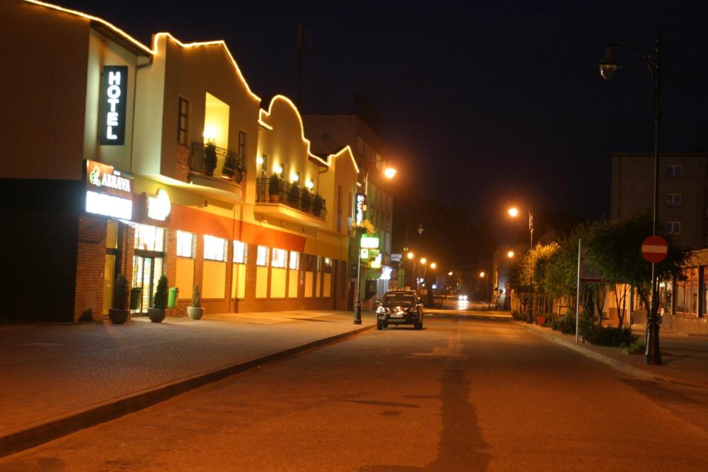 a street at night with a car driving down a street at Hotel Abrava in Drawsko Pomorskie