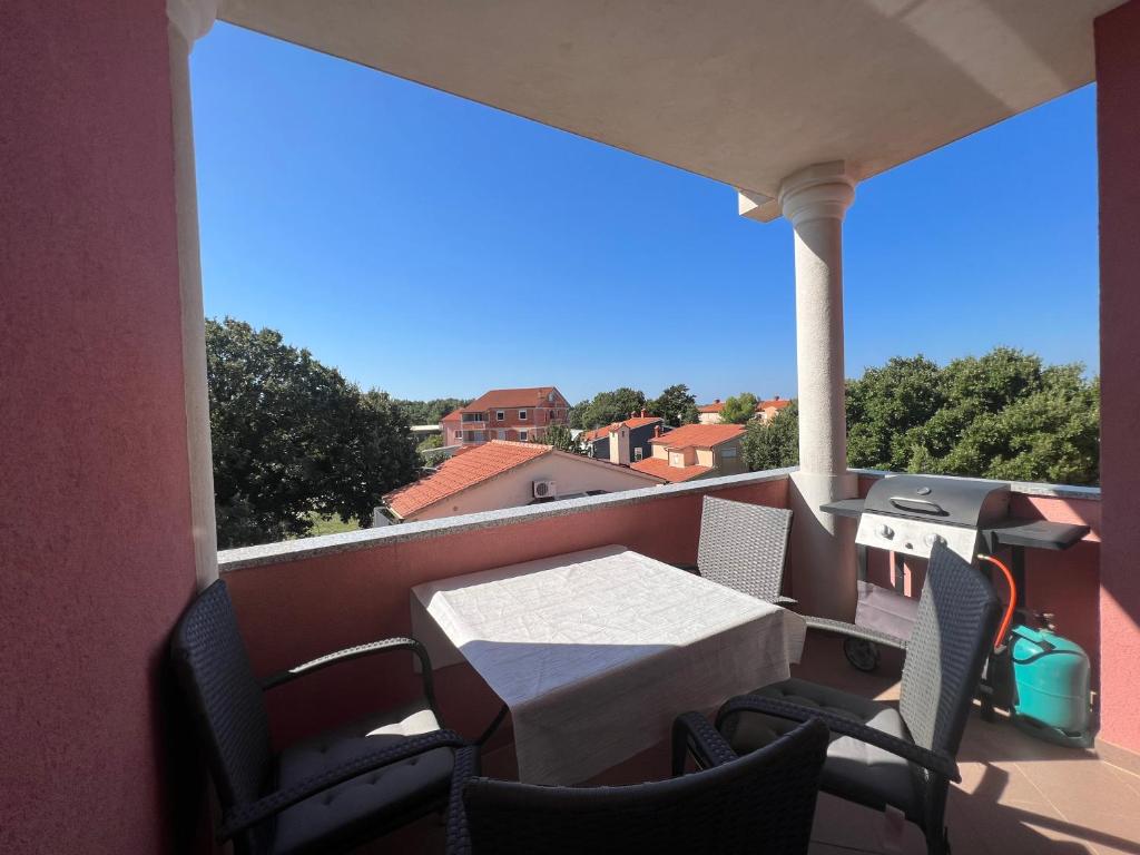 eine Terrasse mit einem Tisch und Stühlen auf dem Balkon in der Unterkunft Apartments Alić in Medulin