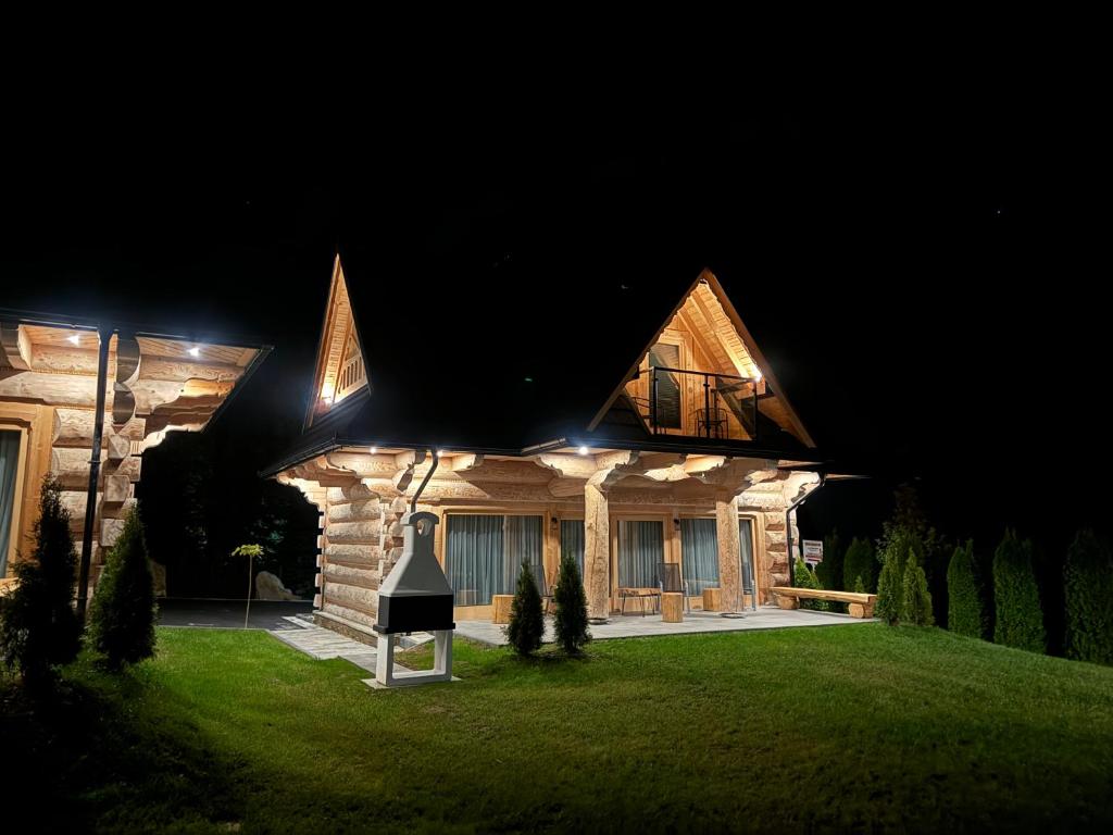 a house at night with lights on it at Domki 4 Turnie in Ząb