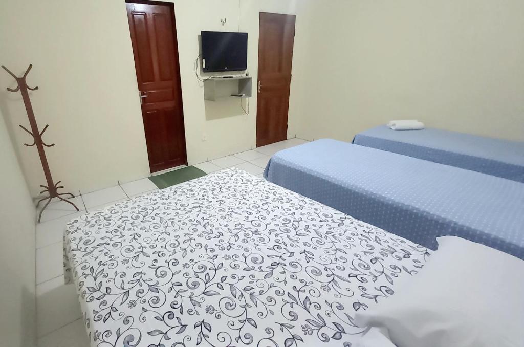 um pequeno quarto com duas camas e uma televisão em Francisca e Manoel em Boa Vista