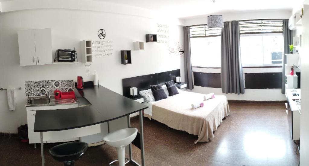 Habitación pequeña con cama, mesa y escritorio. en Shaddai Alojamientos, en Salta
