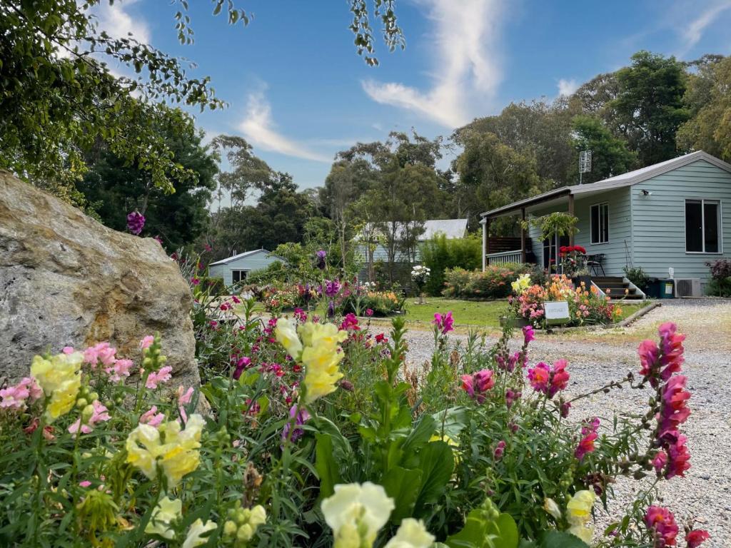 a garden with flowers in front of a house at Tindoona Cottages in Foster