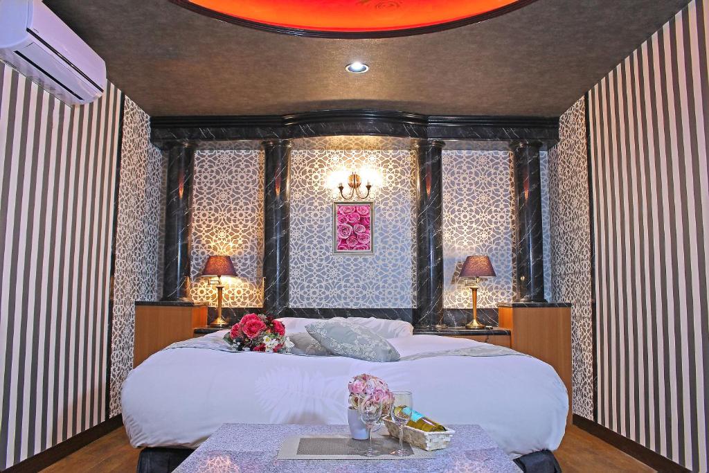 Un dormitorio con una cama grande con flores. en パルアネックス鹿島店, en Ureshino