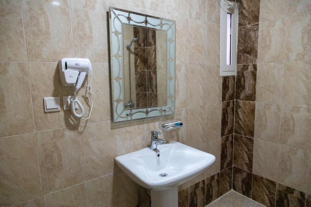 AL manzil ALmutmeez في جدة: حمام مع حوض ومرآة
