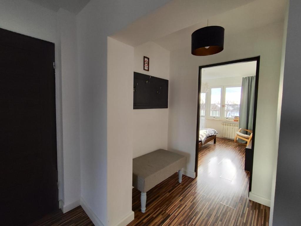 ein weißes Zimmer mit einer Bank und einem Spiegel in der Unterkunft Apartament w centrum in Włodawa