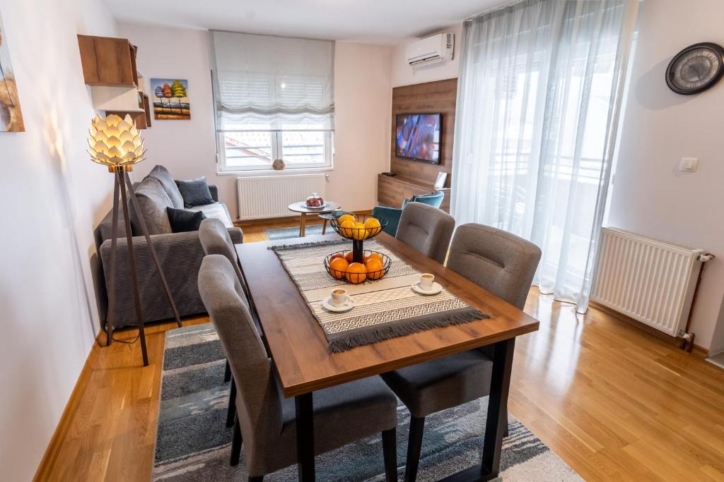 a living room with a dining room table and chairs at Apartman AuRa in Arandjelovac