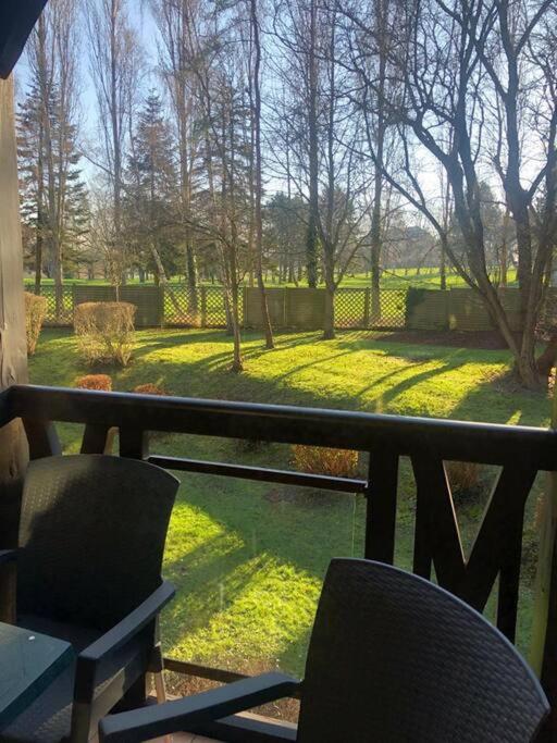- un balcon avec deux chaises offrant une vue sur le jardin dans l'établissement Fairway, à Deauville