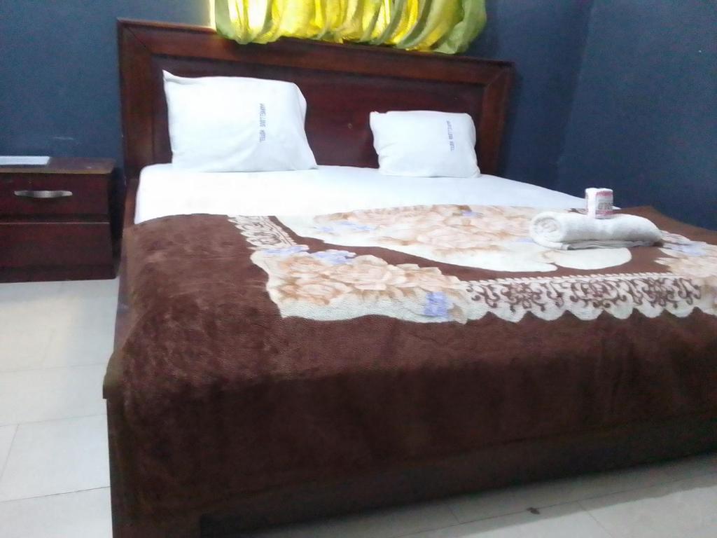拉各斯的住宿－MARVELLOUS hotel，一间卧室配有一张带棕色毯子的床