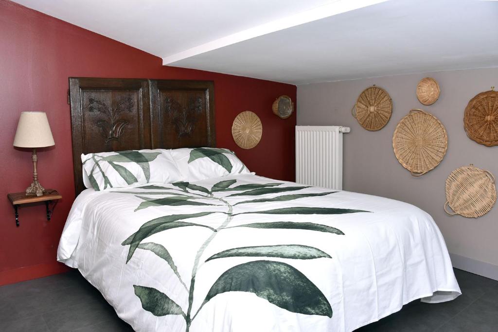 a bedroom with a white bed with a leaf design at Chez Montgaud in Verdun