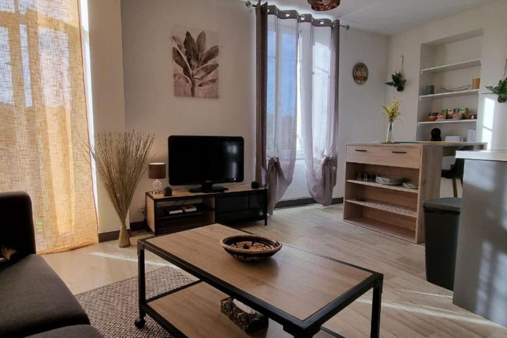 sala de estar con TV y mesa de centro en Superbe appartement avec parking en Saint-Junien